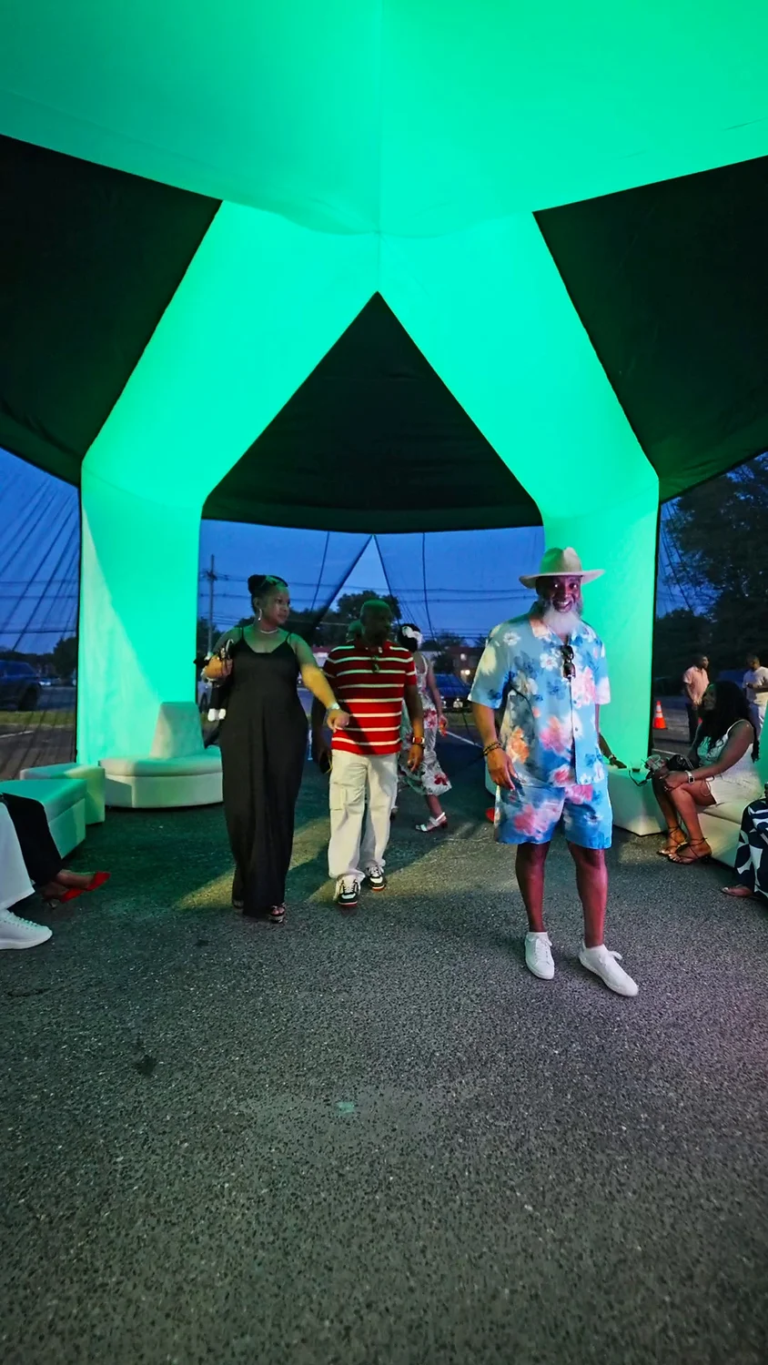 Guests enjoying a green illuminated GlowTent at a real event